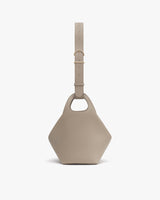 Geometric handbag with a short handle and a single long adjustable strap.