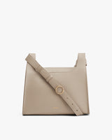 Handbag with adjustable shoulder strap and front metal ring.