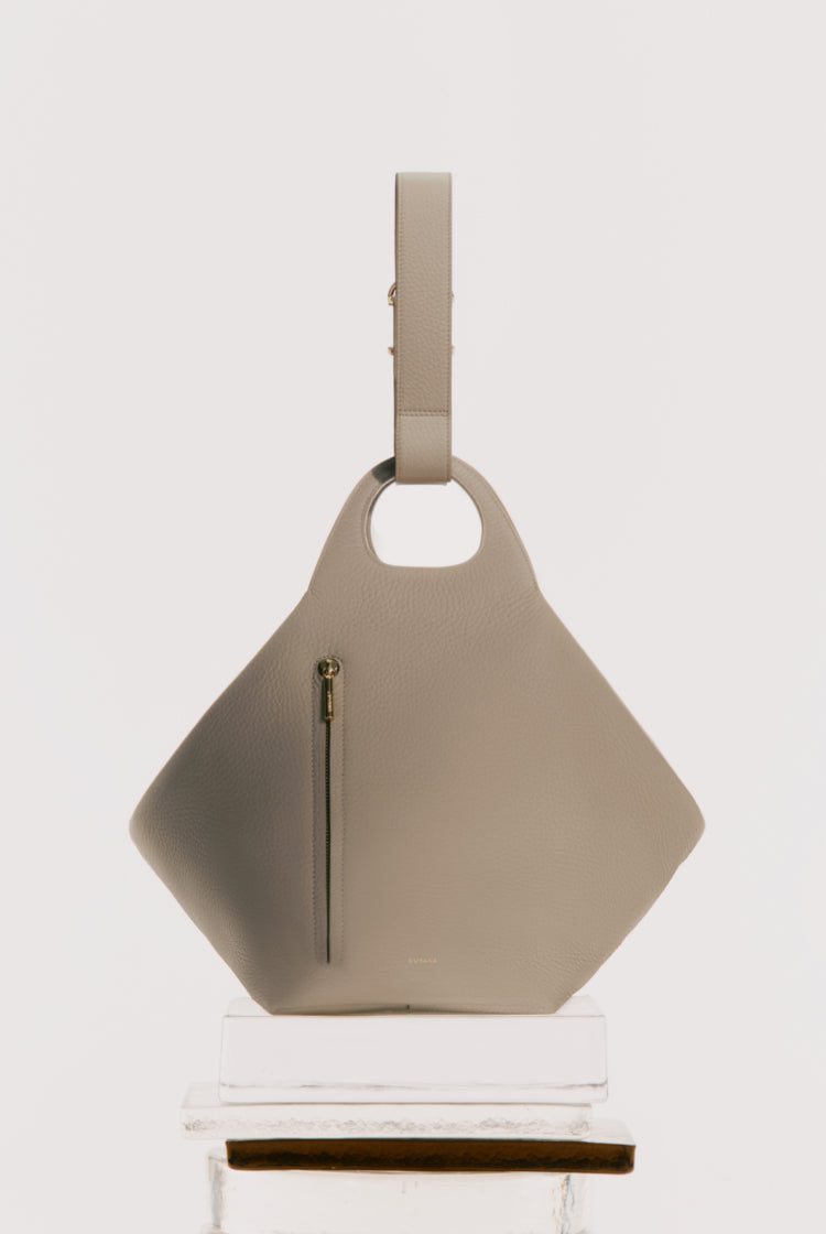 Handbag with a handle and zip on a stand