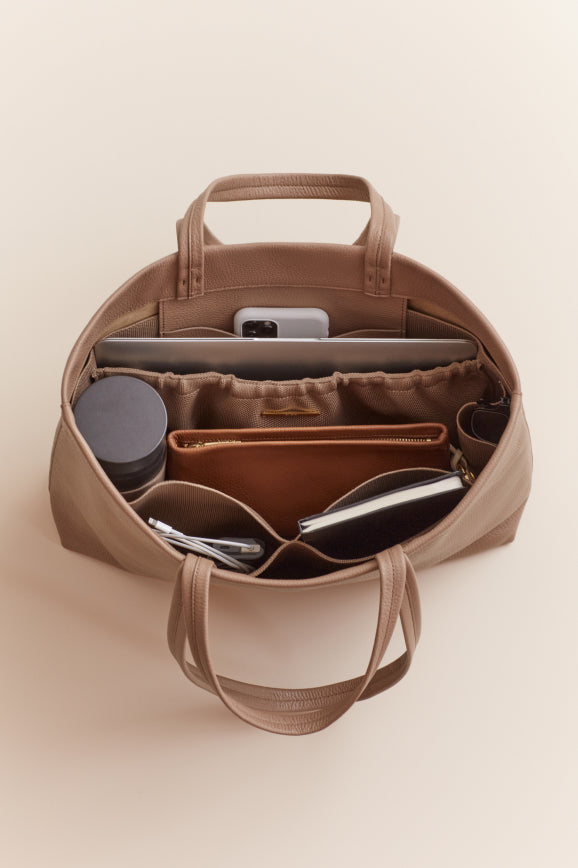 Open handbag with various items organized inside.