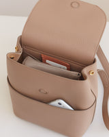 Handbag open with a smartphone and wallet inside.