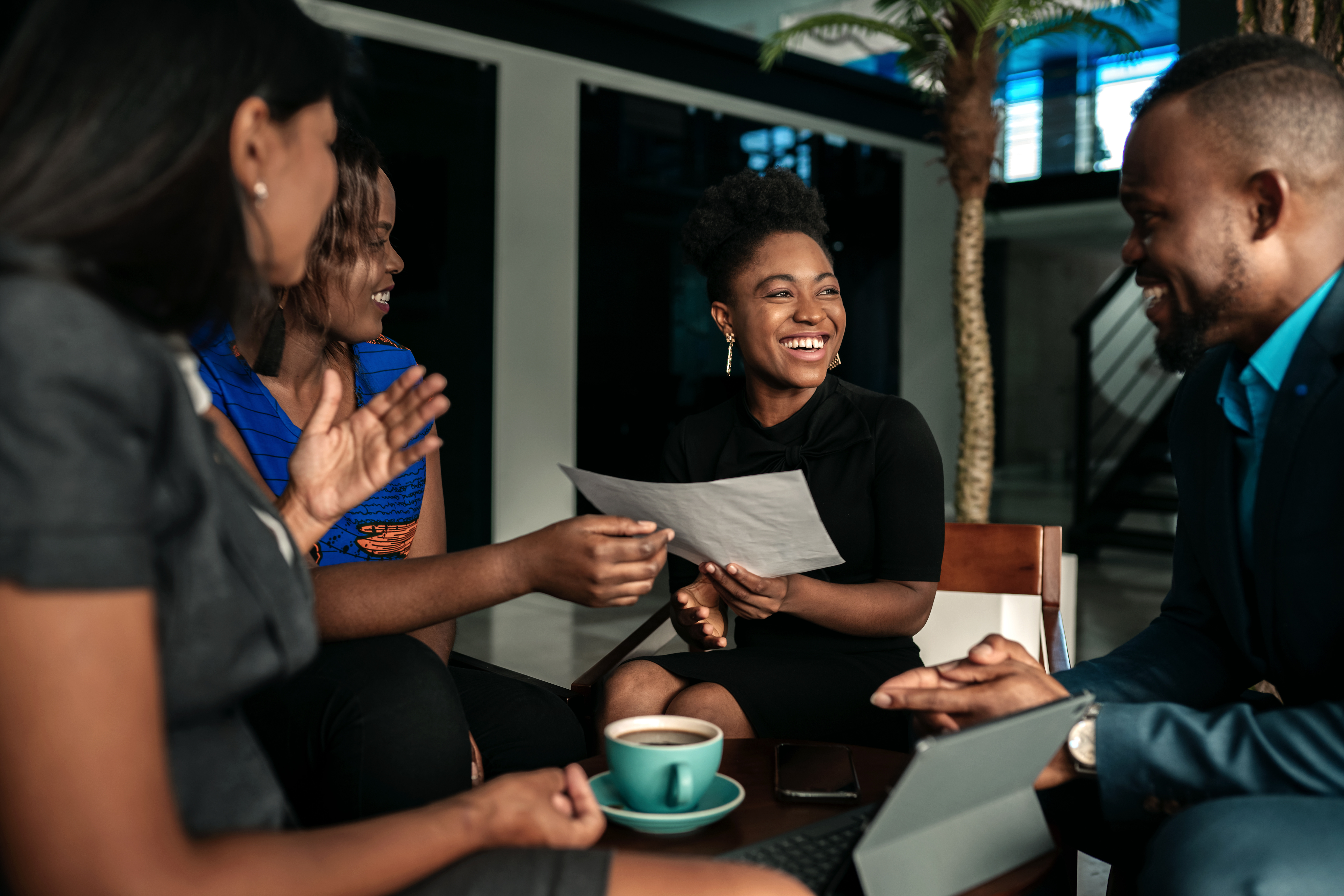 All african casual business meeting. Candid real happy moment between four work colleagues.