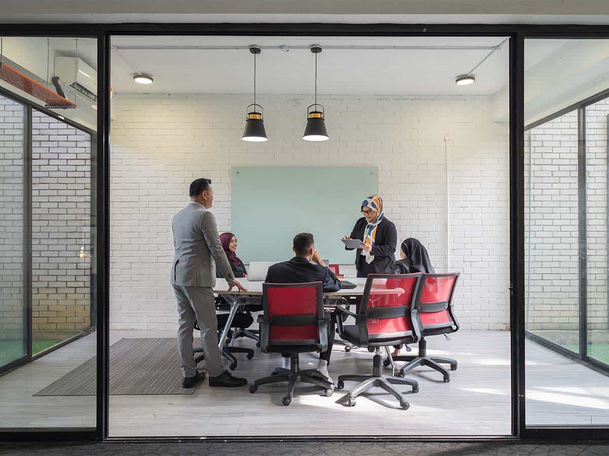 five people in conference room meeting