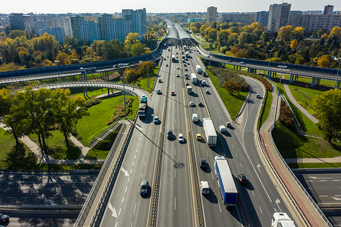 Drone shot at a highway with a clover junction with bridges and ramps, heavy traffic. 