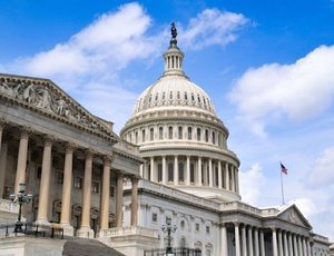 The United States Capitol with a partly cloudy sky in the background