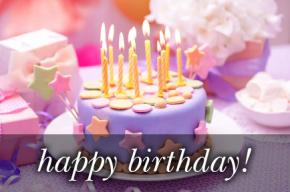 Image of a birthday cake with lit candles and the text 