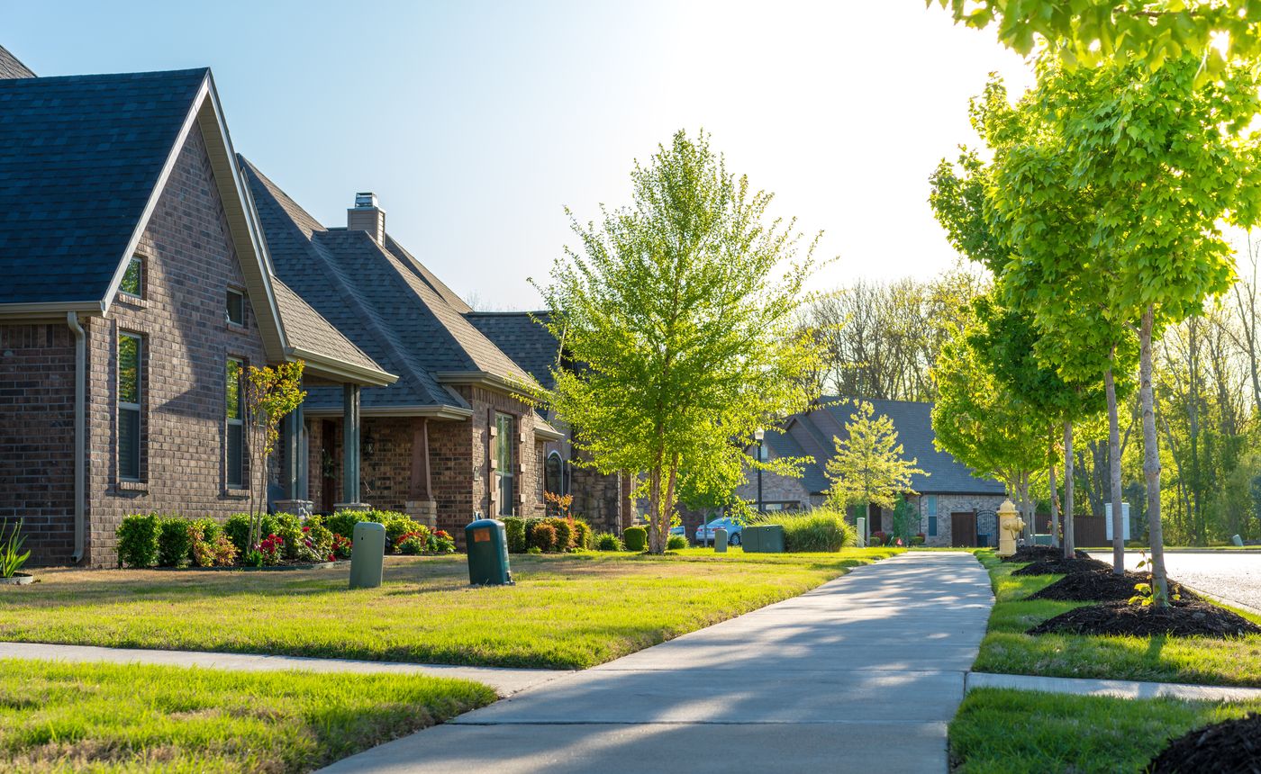 A residential street lined with houses with large green front yards.