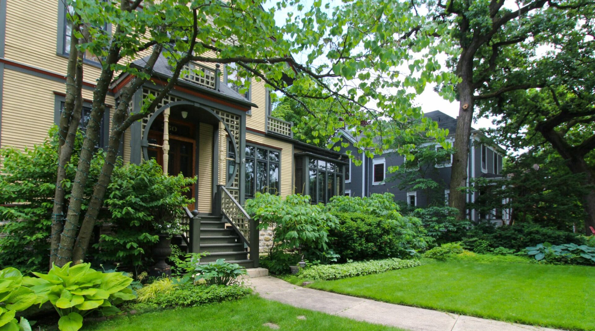 Historic home in Chicago with green front yard and large front porch.