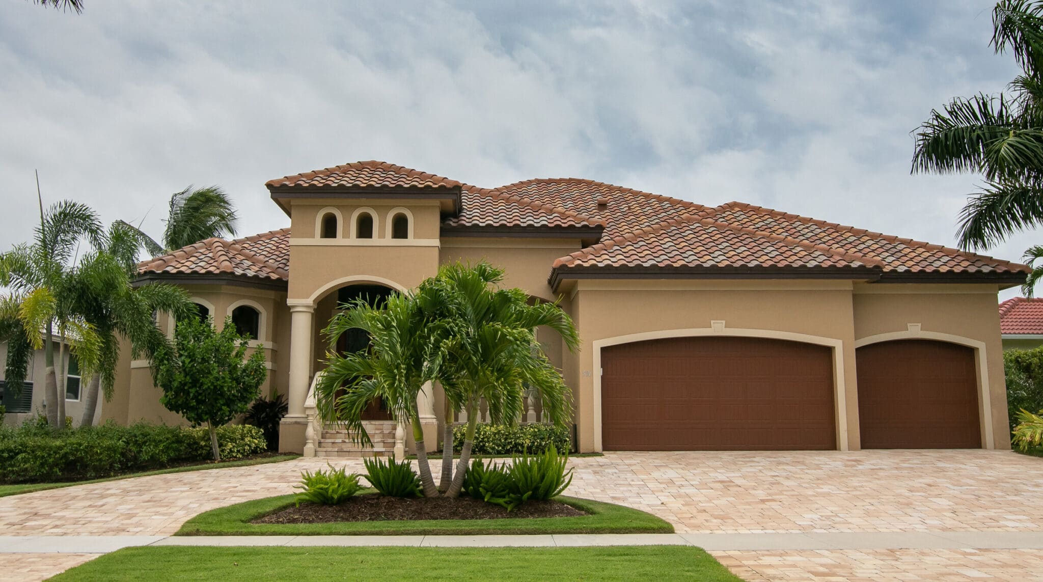 Private Spanish style home with green lawn on Marco Island in Florida.