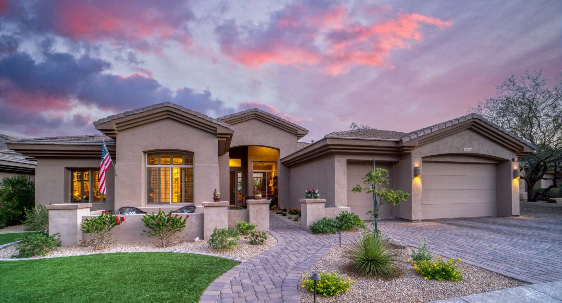 A home in Arizona with a Spanish roof a green front yard.