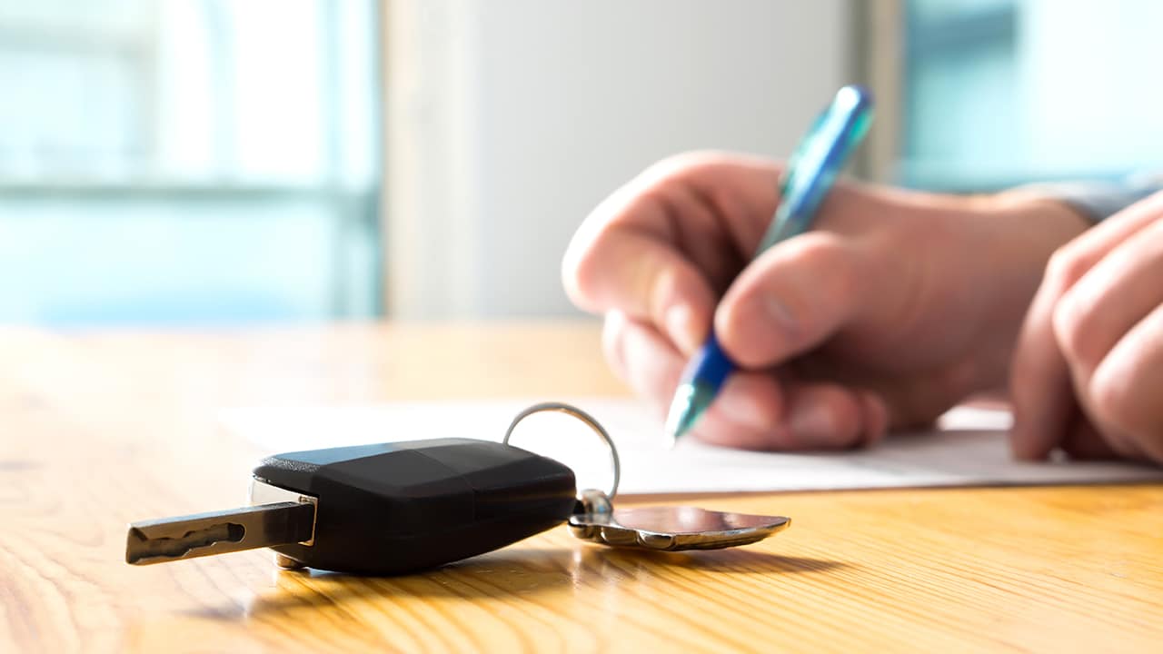 Man signing car insurance document or lease paper.