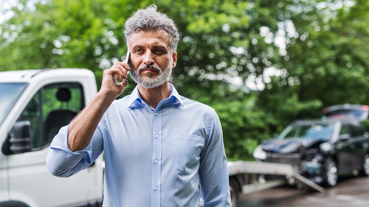 Mature man making a phone call after a car accident. Copy space.