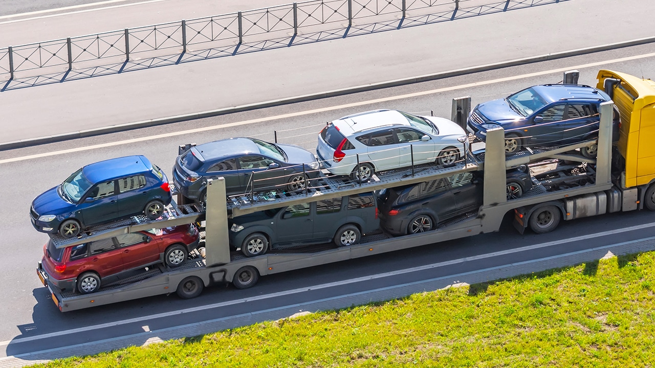 Transportation of new cars on a trailer with a truck for delivery to dealers