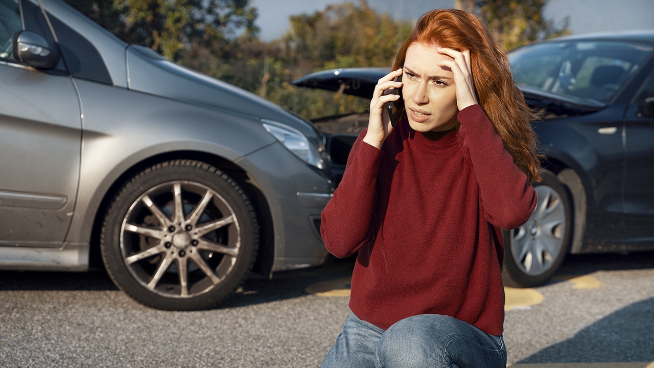 Woman calling insurance service after car crash