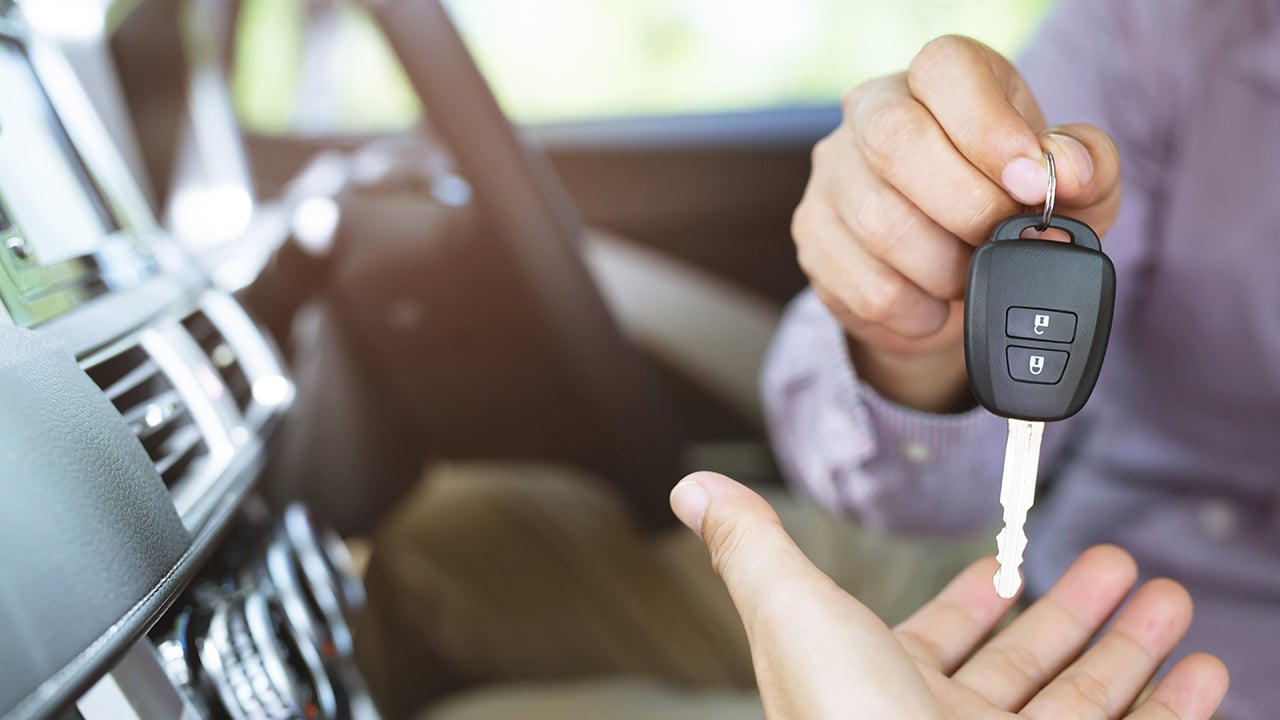 Car key, businessman handing over gives the car key to the other