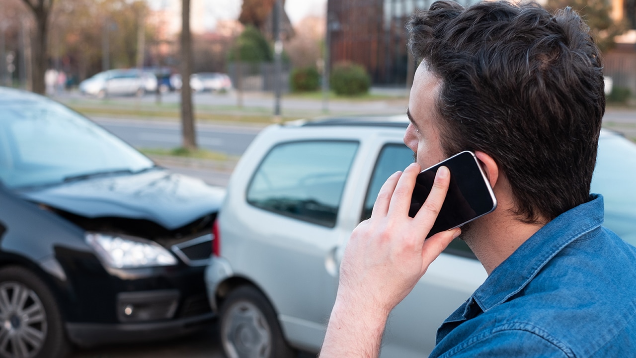 Man calling roadside service after car crash