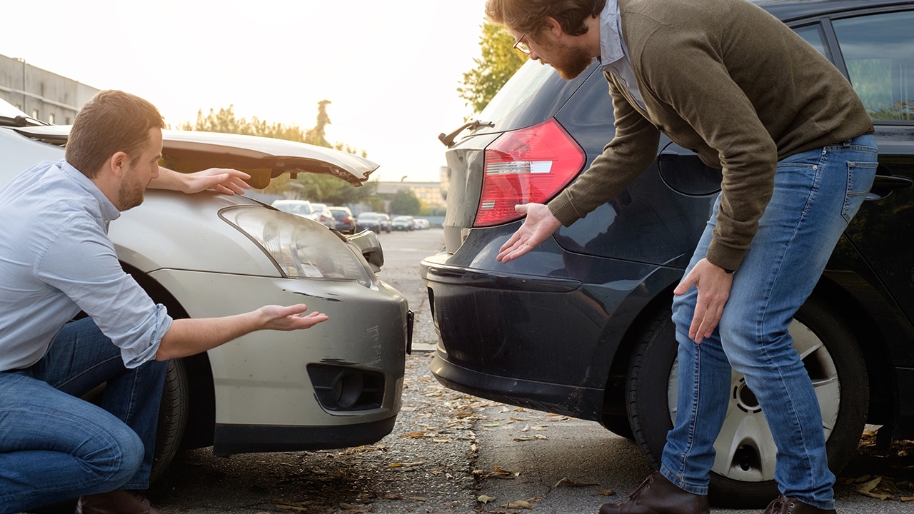 Two men arguing after a car accident on the road