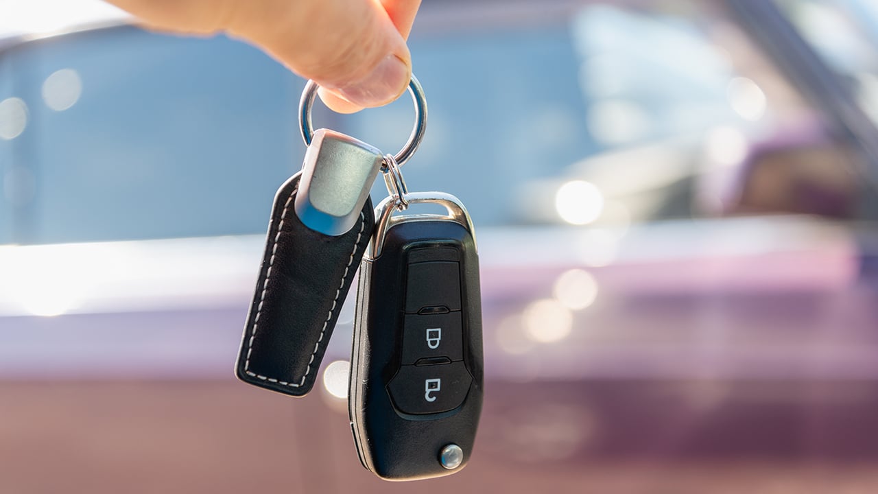 Keys and car in the background. Sale, purchase of a car.