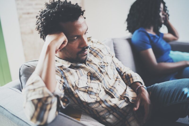 Unhappy couple on a couch wanting an uncontested divorce.