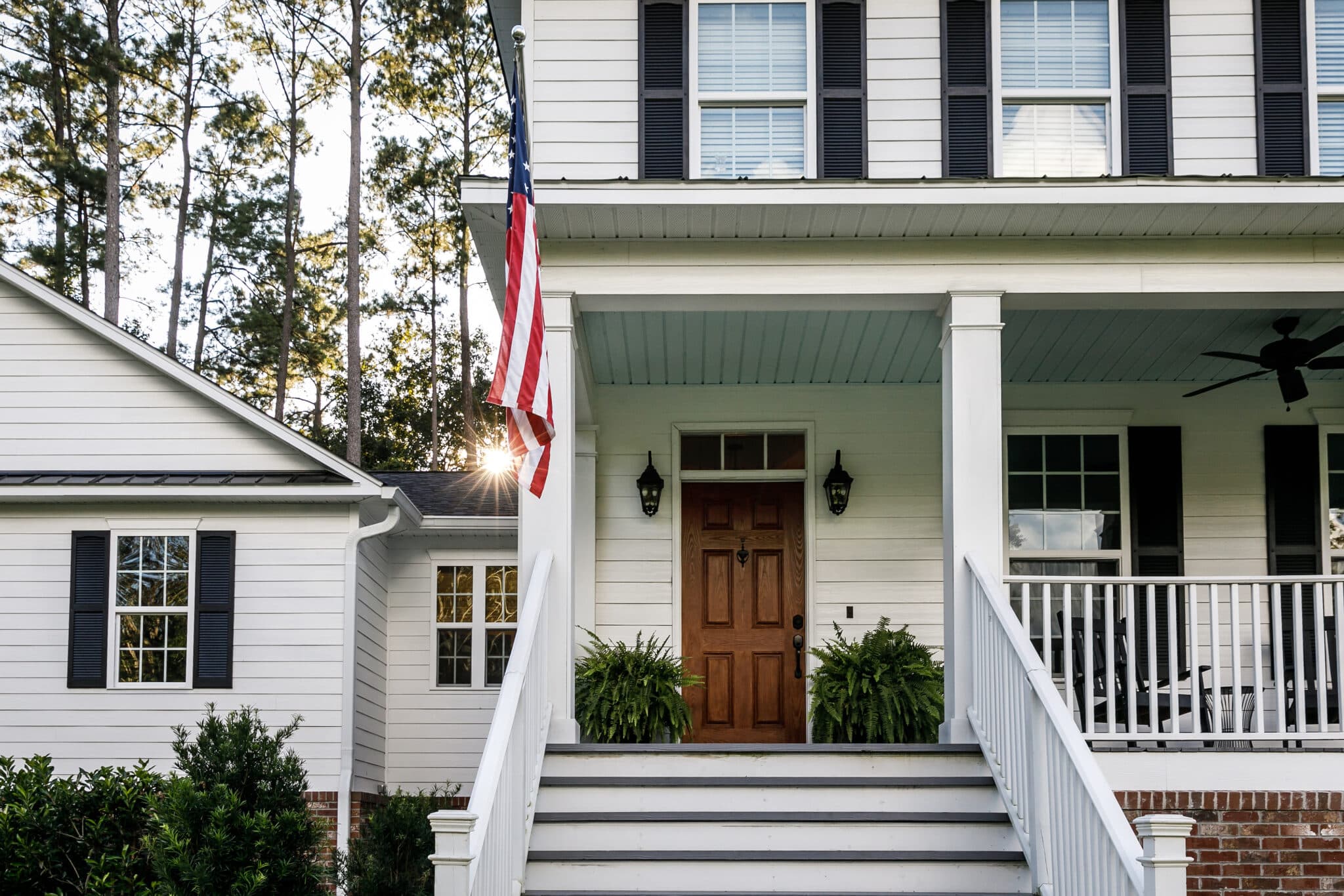 Front Porch with Stairs of All American White Farmhouse with Wood Doors