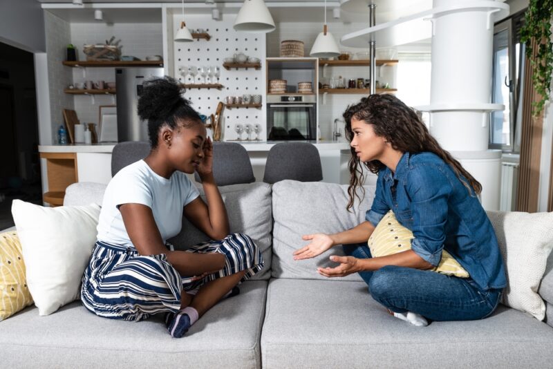 Two unhappy women on a couch considering using Hello Divorce.