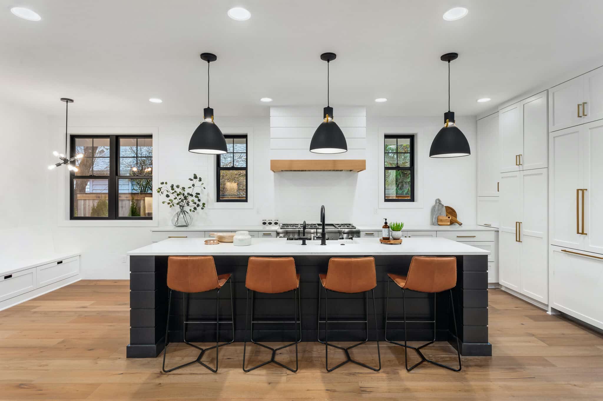 Beautiful white kitchen with dark accents in new modern farmhouse style luxury home