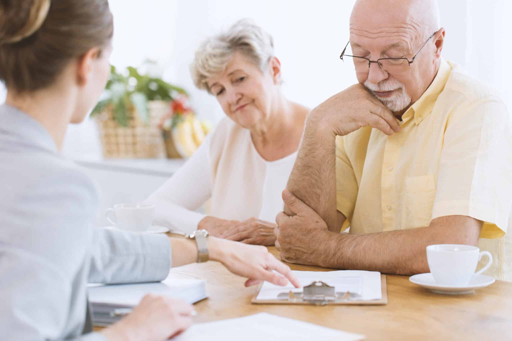 Couple of reasonable senior people signing life insurance during a meeting with advisor