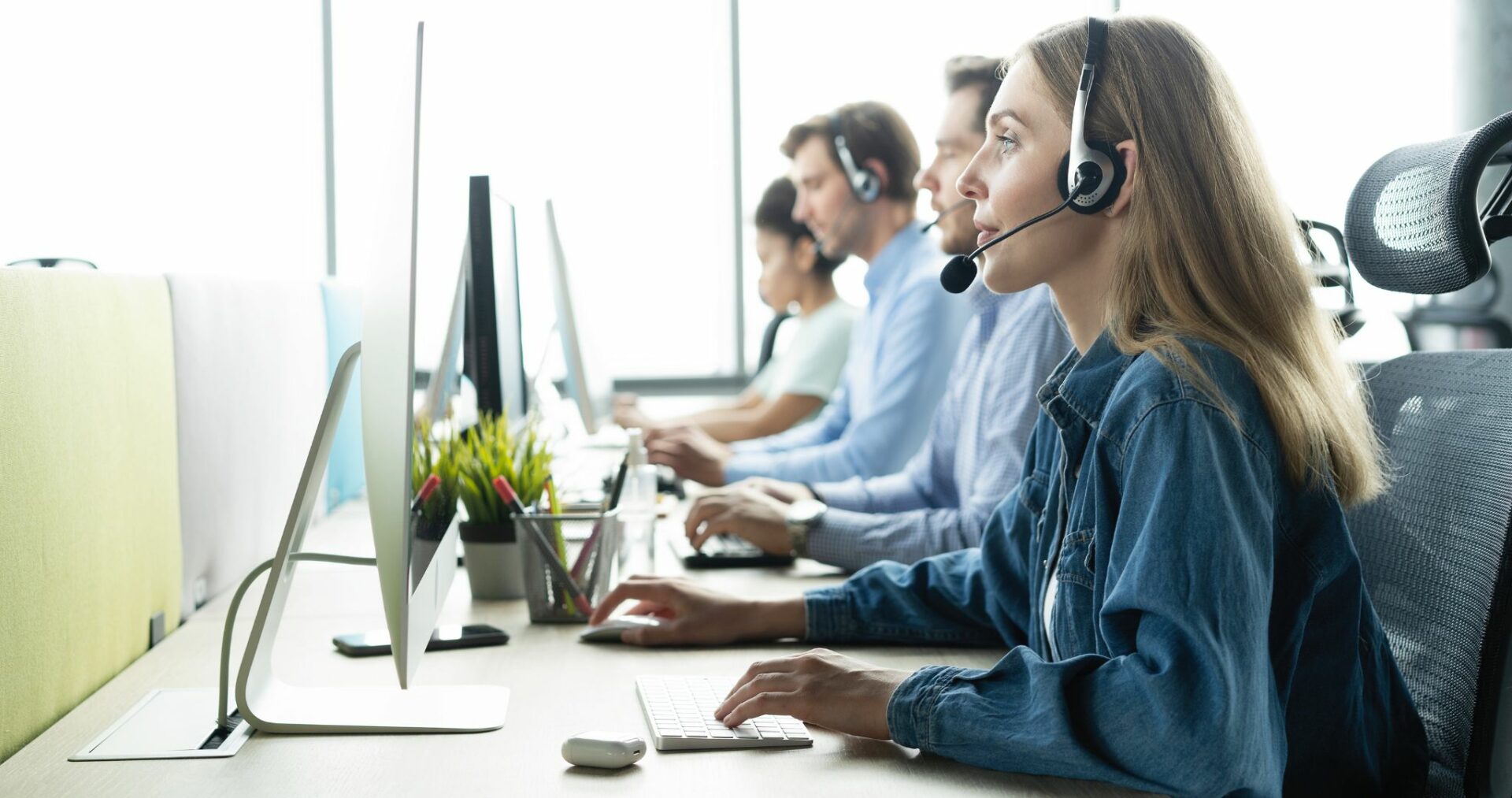 A girl is talking on the headphone in a workplace