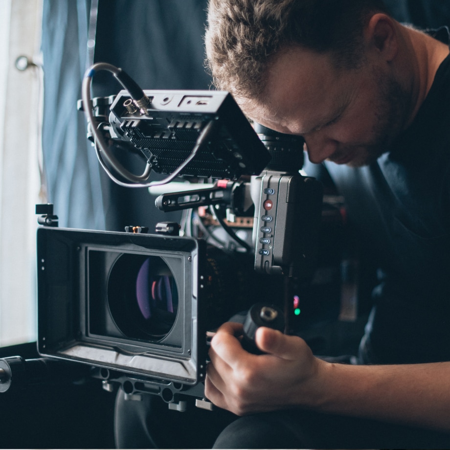 Man looks into movie-making camera