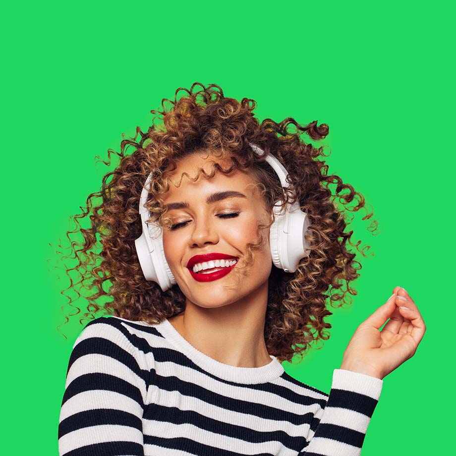 Femme avec un casque audio sur les oreilles en train de sourire