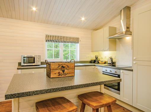 Kitchen area with island unit and stools