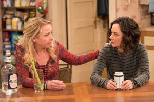 Becky comforts Darlene at the Conner family table.