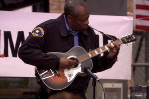 High Dane plays guitar as Hank the security guard.