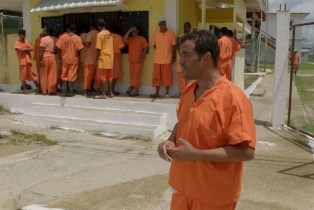 Raphael Rowe stands outside in a prison in Belize.