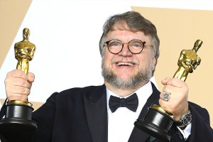 Guillermo del Toro holding two Oscars