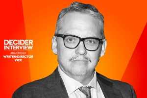 Adam McKay in black and white on a bright orange background