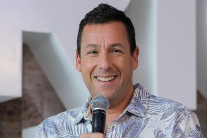 Adam Sandler holds a microphone