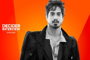 Avan Jogia in black and white on a bright orange background