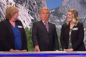 Pat Sajak looking shocked next to two Wheel of Fortune contestants