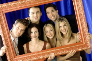 Friends cast together behind a photo frame