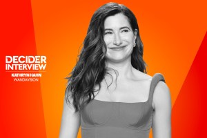 Kathryn-Hahn in black and white on a bright orange background