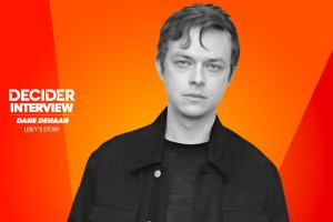 Dane DeHaan in black and white on a bright orange background