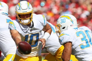 Los Angeles Chargers quarterback Justin Herbert (10) looks to hand off to running back Austin Ekeler (30) in the first quarter of an AFC West matchup between the Los Angeles Chargers and Kansas City Chiefs on Sep 26, 2021 at GEHA Filed at Arrowhead Stadium in Kansas City, MO. (Photo by Scott Winters/Icon Sportswire via Getty Images)