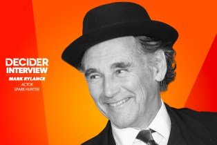 MARK RYLANCE in black and white on a bright orange background