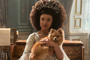 Young Queen Charlotte holding a dog in 'Queen Charlotte: A Bridgerton Story'