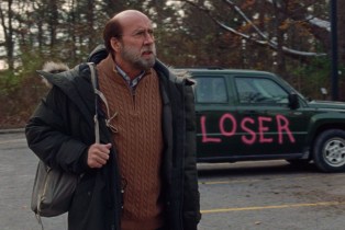 Nicolas Cage dressed as a balding man in a chunky sweater in the movie DREAM SCENARIO