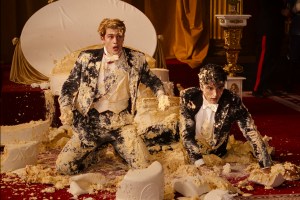 a Still from Red White and Royal Blue: Alex and Henry covered in wedding cake