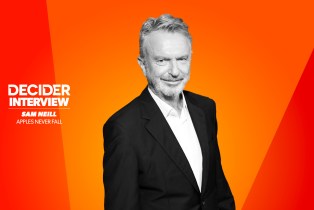 Sam Neill in black and white on a bright orange background