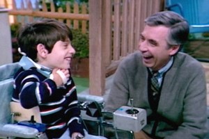 Mister Rogers laughing on set with a child.