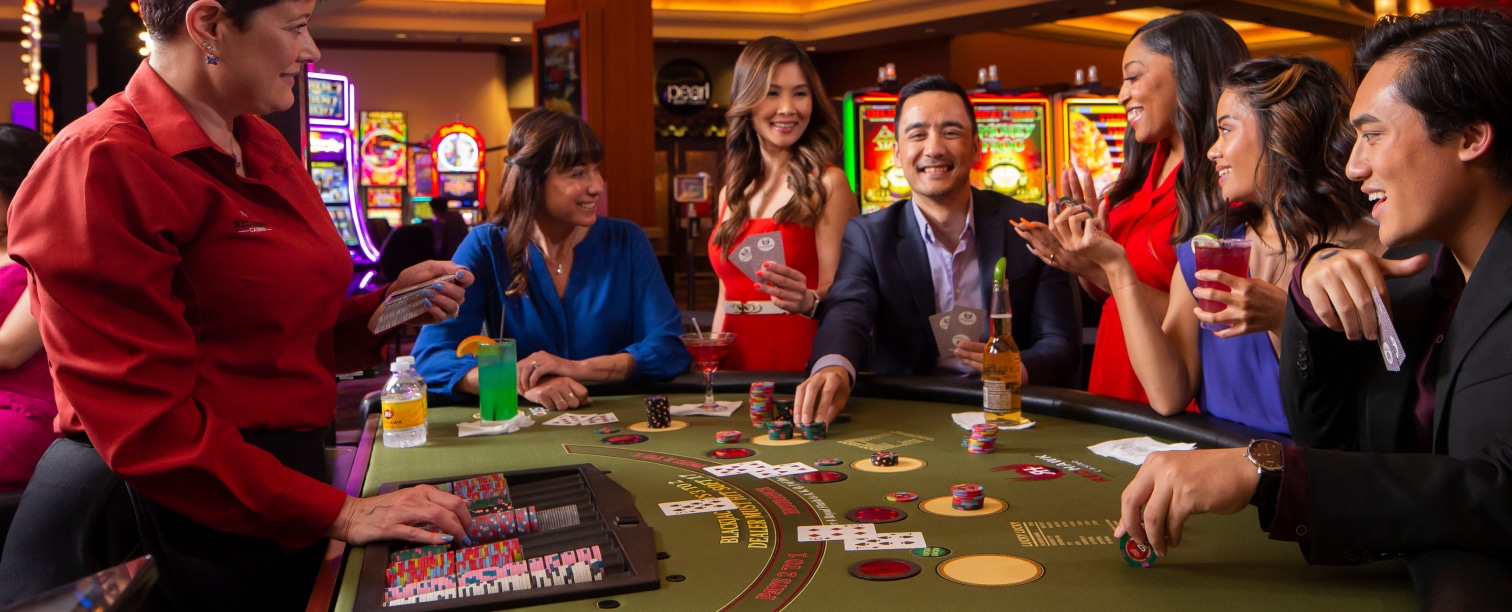 Players sitting at a blackjack table, playing blackjack.